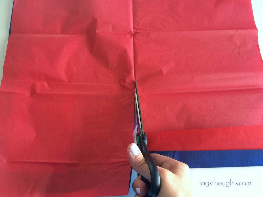 Red tissue paper and scissors used for step one of tissue sparklers.