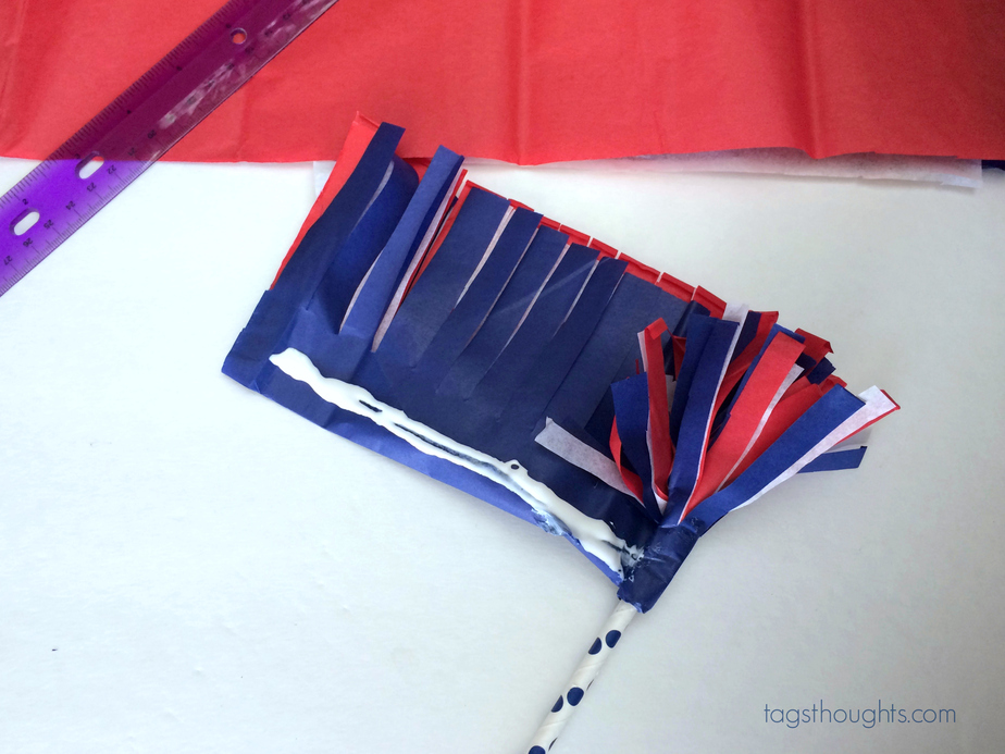 Red, white and blue tissue paper wrapped around a white & blue striped straw.